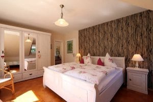 Doppelbett der Ferienwohnung Lindenblüte mit Fototapete an der Rückwand des Bettes