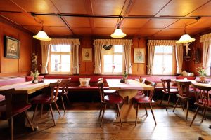 Historische Gaststube mit Eckbank und großen Tischen im Gasthaus Zur Linde